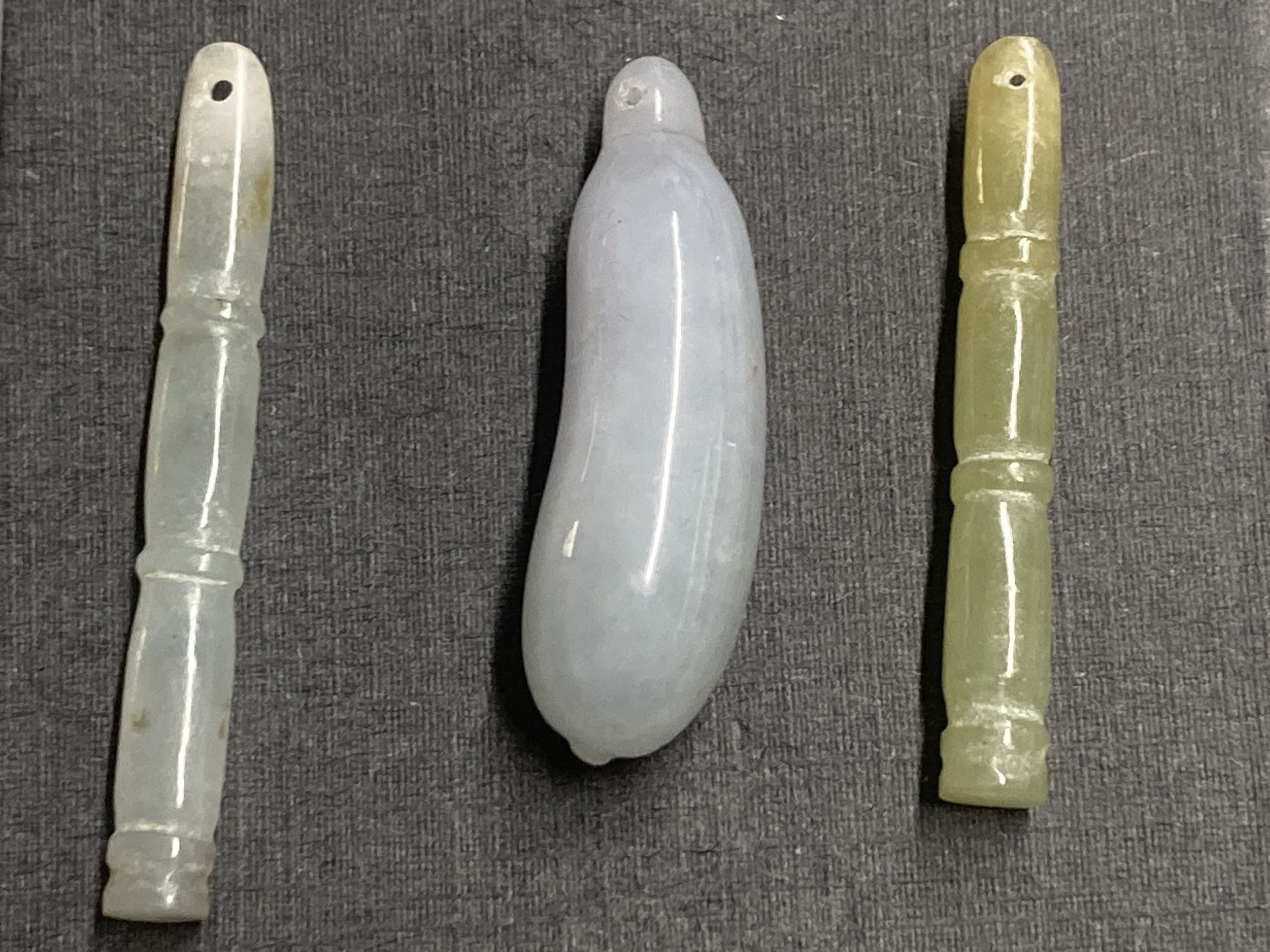 A Chinese jadeite gourd pendant, largest 43mm and two hardstone faux bamboo pendants.